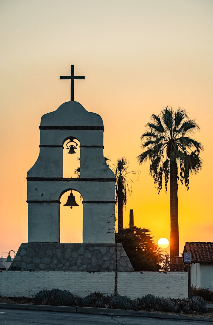 Beautiful sunset view of the historic mission bell tower with palm trees in Redlands, California.