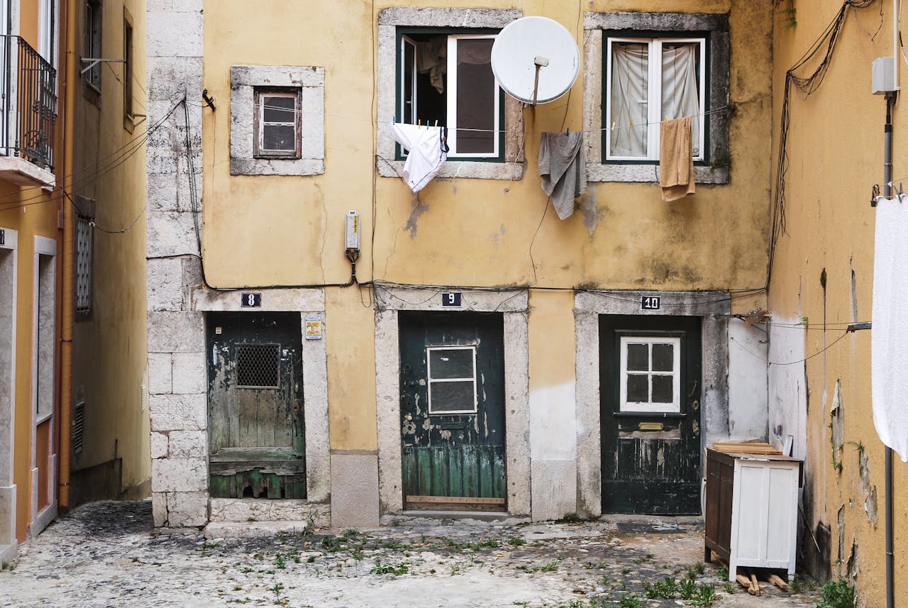 View of a dilapidated building facade with drying laundry in Lisbon, Portugal.
